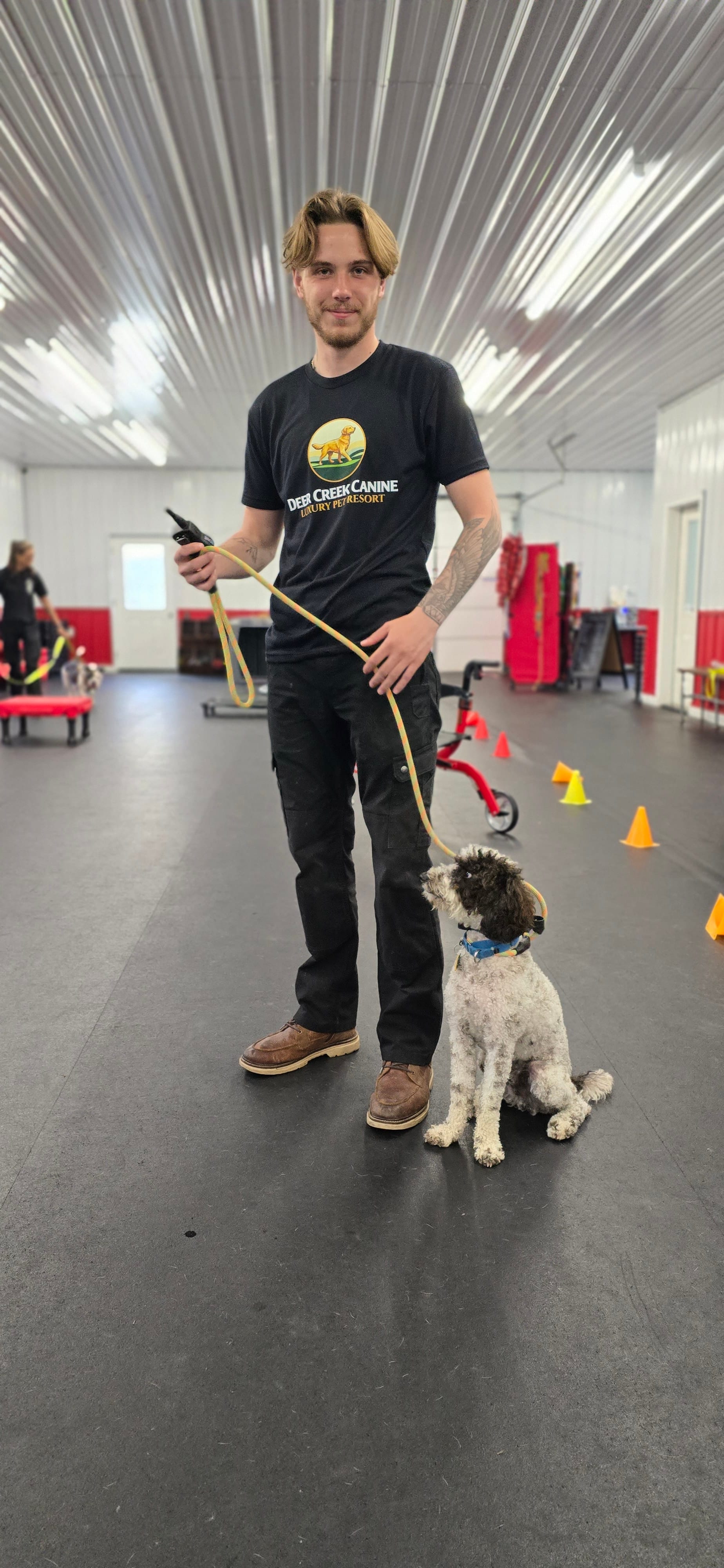 A calm shepherd-style dog working obedience with a Deer Creek trainer